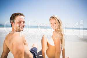 Happy couple sitting on the beach