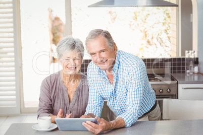 Portrait of happy senior couple with tablet