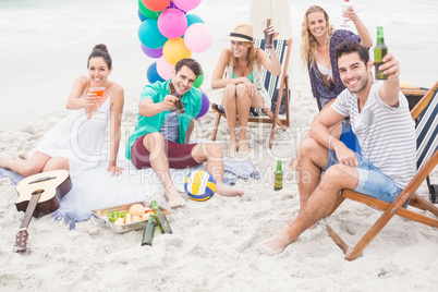 Group of friends toasting beer bottles on the beach