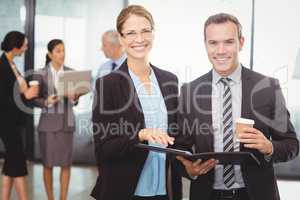 Portrait of businessman and businesswoman holding file