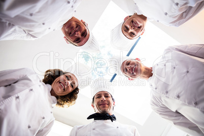 Portrait of chefs team standing in a circle wearing uniforms