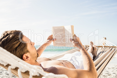 Man reading book in hammock