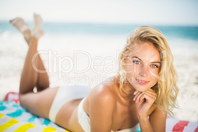 Smiling woman lying on a towel at the beach