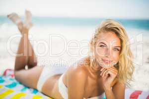 Smiling woman lying on a towel at the beach