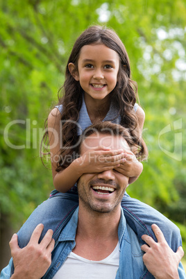 Father carrying her daughter on shoulder