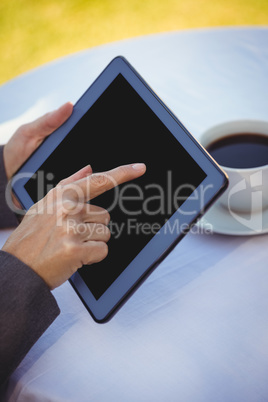 Businesswoman using tablet with coffee