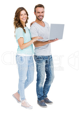 Portrait of happy young couple using laptop