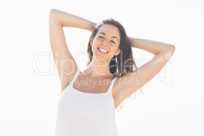 Happy woman in white outfit standing on the beach