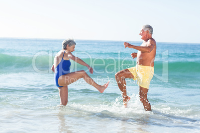 Senior couple playing with waves