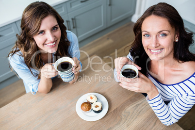 High angle portrait of female friends holding coffee mugs