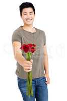 Happy young man holding bunch of red roses