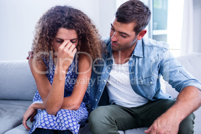 Young couple sitting together and discussing after a fight