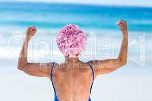 Pretty mature woman showing her muscles on the beach