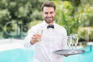 Smiling waiter offering champagne