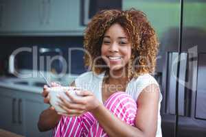 Happy woman having breakfast in kitchen