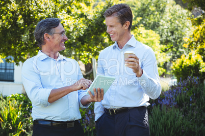 Two businessmen meeting using tablet