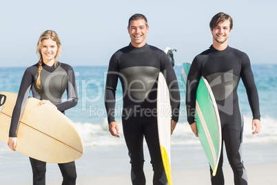 Portrait of surfer friends with surfboard standing on the beach