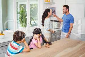Children sitting at table with parents quarreling