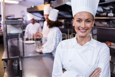 Happy chef standing in commercial kitchen in a restaurant