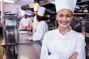 Happy chef standing in commercial kitchen in a restaurant