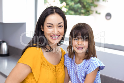 Young woman with her daughter in kitchen