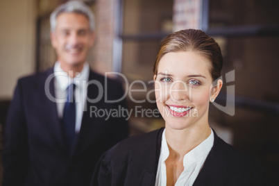 Female lawyer smiling while male colleague in background