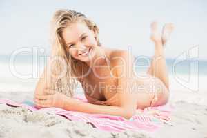 Happy woman in bikini lying on the beach