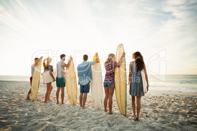 Friends holding surfboard on the beach