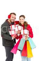 Happy young couple holding gifts and shopping bags