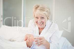 Happy senior woman taking medicine