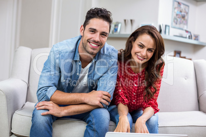 Cheerful couple sitting on sofa