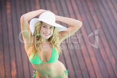 Happy woman in hat standing on wooden deck