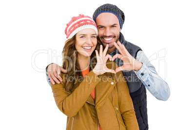 Happy young couple making heart gesture