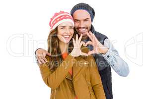 Happy young couple making heart gesture