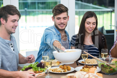 Friends having meal at table in house