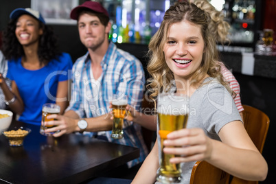 Smiling blonde woman offering beer