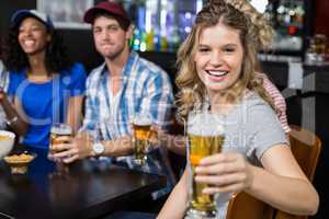 Smiling blonde woman offering beer