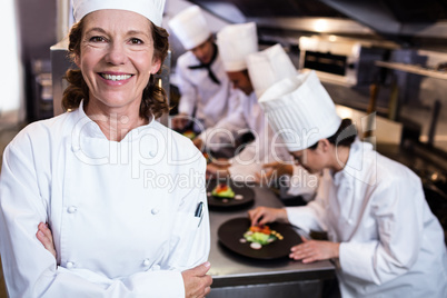 Head chef smiling in busy kitchen