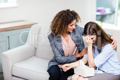 Psychologist consoling depressed woman at home