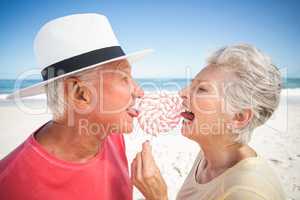 Senior couple licking lollipop