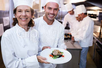 Two chefs presenting their dishes
