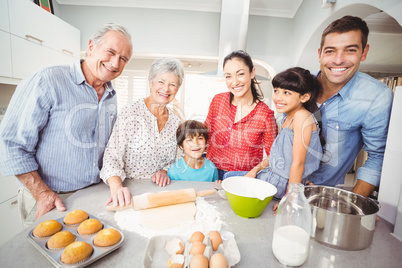 Portrait of happy family making bread in kitchen