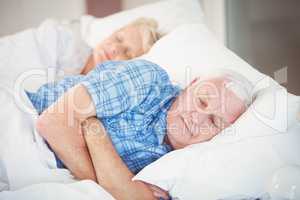 Senior couple sleeping on bed