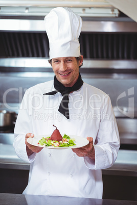 Chef holding a dish with salad