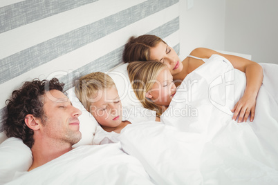 High angle view of family relaxing on bed