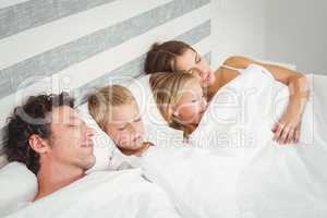 High angle view of family relaxing on bed