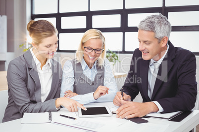 Business people discussing with client over digital tablet