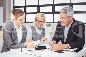 Business people discussing with client over digital tablet