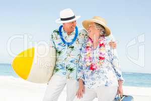 Senior couple holding surfboard