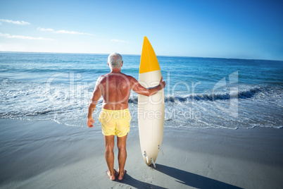 Senior man posing with a surfboard